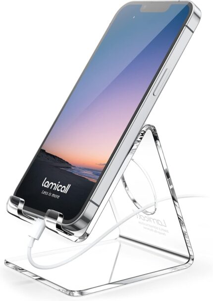 A clear acrylic cell phone stand holding a smartphone on a desk, showcasing its transparent design and cable management.